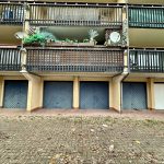 Row of garages and balconies with satellite dish.