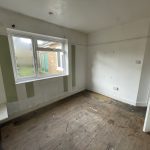 Empty room with wooden floor and striped walls.