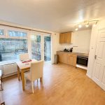 Modern kitchen with dining table and garden view.