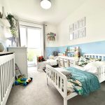 Bright children's room with twin beds and toys.