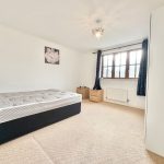 Bright bedroom with bed, furniture and window view.