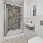 Modern bathroom with shower and wall tiles.