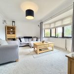 Modern living room with grey sofas and wooden furniture.