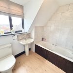 Modern bathroom with bathtub and window view.