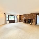 Spacious living room with brick fireplace and soft lighting.