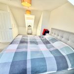 Bright bedroom with double bed and wardrobe.