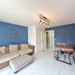 Modern living room with blue accent wall and furniture.