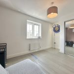 Modern living room with dartboard and large mirror.