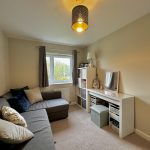 Cosy living room with sofa and desk.