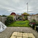 Backyard garden with patio and wooden fence.