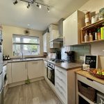 Modern kitchen with white cabinets and large window