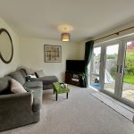 Cosy living room with garden view and grey sofa.