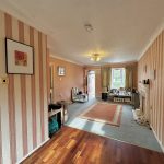 Spacious living room with striped wallpaper.