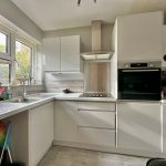 Modern kitchen with white cabinets and appliances.
