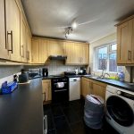 Modern kitchen with wooden cabinets and appliances.