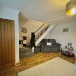 Cosy living room with stairs and seating area.