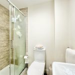 Modern bathroom with shower, toilet, and sink.