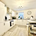 Modern white kitchen with appliances and countertops.