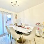 Modern dining room with marble table and chairs.