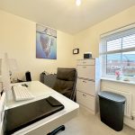 Home office with desk, chair, and filing cabinet.