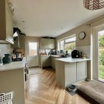 Modern kitchen with cream cabinets and garden view.