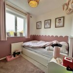 Decorated child's bedroom with pink accents and toys.