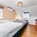 Modern bedroom with double beds and wooden furniture.