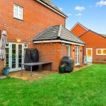 Brick house backyard with green lawn.