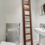 Bathroom with ladder and sink, modern radiator visible.