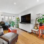 Modern living room with plants and guitars.