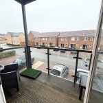 View of street and houses from a balcony.