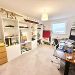 Home office with shelves and desk setup.