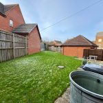 Residential backyard with lawn, fence, and table.