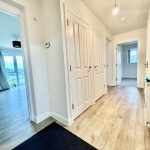 Modern hallway with wooden flooring and white doors.