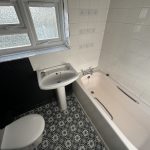 Compact bathroom with bath, sink, and toilet.