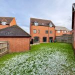 Brick houses with snowy garden lawn.