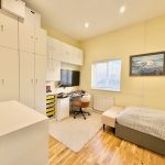 Cosy bedroom with desk and storage units.
