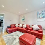Modern living room with red sofas and artwork.