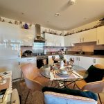 Modern kitchen with dining table and decorative touches.