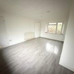 Unfurnished room with laminate flooring and large window.