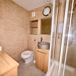 Modern bathroom with shower, toilet, and stone sink.