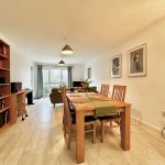 Spacious dining room with wooden furniture and shelves.