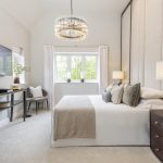 Modern bedroom with stylish decor and large window.