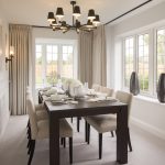Elegant dining room with large windows and chandelier.