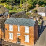 Aerial view of charming brick houses with gardens.