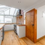 Bright kitchen with skylight and wooden flooring.