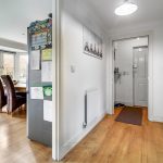 Bright hallway leading to dining area with windows.