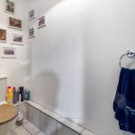 Small bathroom with framed pictures and toiletries.