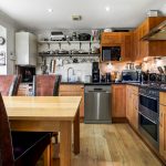 Modern kitchen with wooden cabinets and dining table.