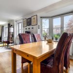 Bright dining area with wooden furniture and plants.
